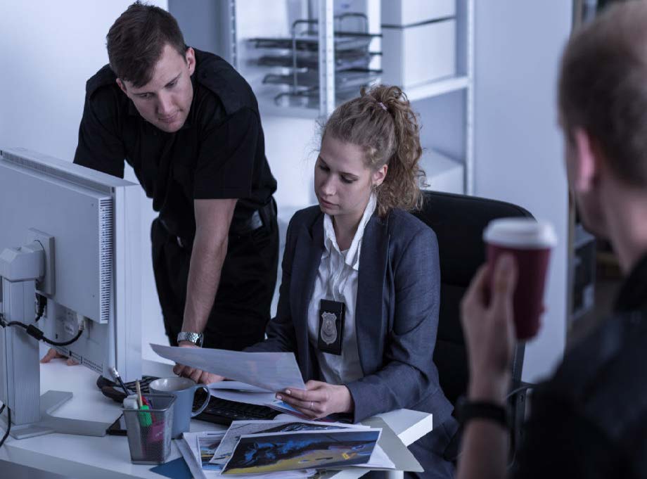 Male and Female detectives reviewing papers at a desk